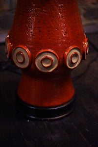 A stunning and unusual mid-century pottery lamp. The lamp has a lovely vermilion glaze and interesting shape.  reminiscent of works by Raymor and Bitossi.