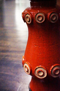 A stunning and unusual mid-century pottery lamp. The lamp has a lovely vermilion glaze and interesting shape.  reminiscent of works by Raymor and Bitossi.