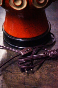 A stunning and unusual mid-century pottery lamp. The lamp has a lovely vermilion glaze and interesting shape.  reminiscent of works by Raymor and Bitossi.