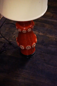 A stunning and unusual mid-century pottery lamp. The lamp has a lovely vermilion glaze and interesting shape.  reminiscent of works by Raymor and Bitossi.