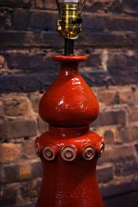 A stunning and unusual mid-century pottery lamp. The lamp has a lovely vermilion glaze and interesting shape.  reminiscent of works by Raymor and Bitossi.