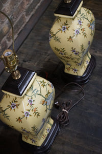 Lovely pair of matching hand painted ceramic lamps from Bradburn.  They have a yellow field and hand painted birds and greenery.