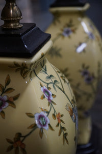 Lovely pair of matching hand painted ceramic lamps from Bradburn.  They have a yellow field and hand painted birds and greenery.