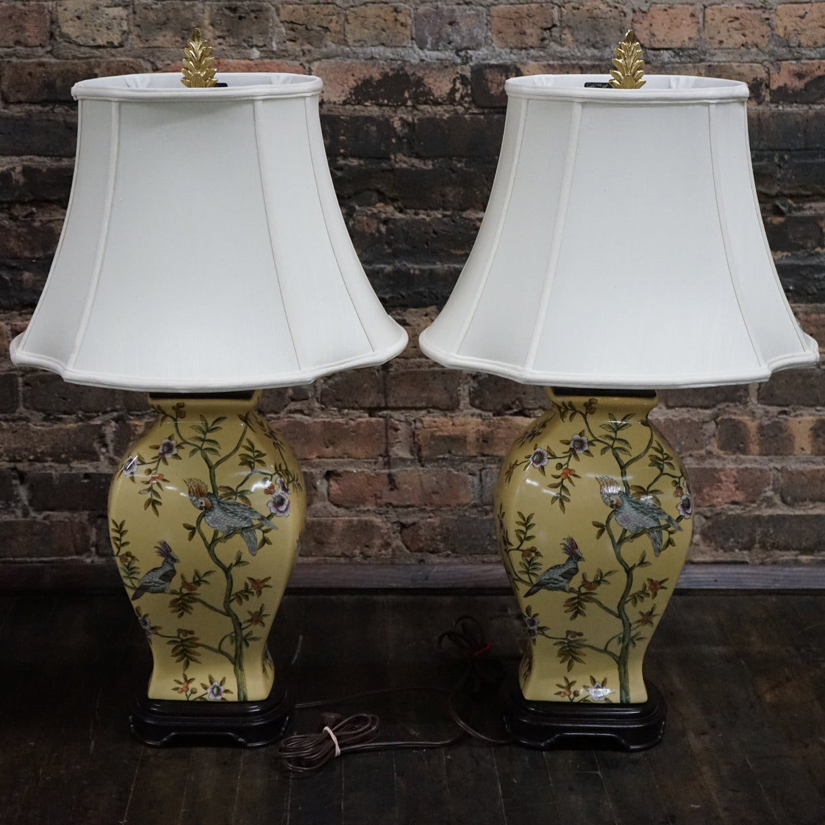 Lovely pair of matching hand painted ceramic lamps from Bradburn.  They have a yellow field and hand painted birds and greenery.