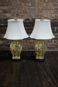 Lovely pair of matching hand painted ceramic lamps from Bradburn.  They have a yellow field and hand painted birds and greenery.