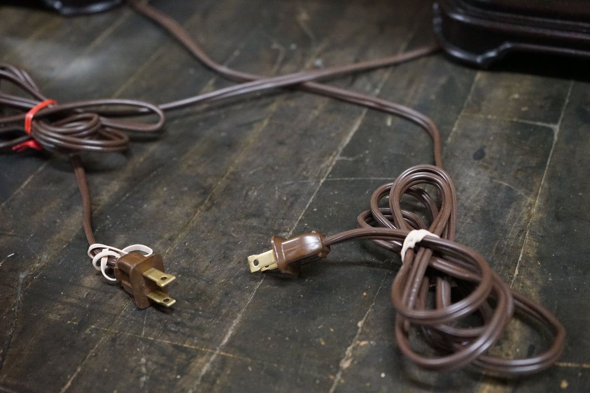 Brown electrical cord with plug on a wooden surface
