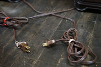 Brown electrical cord with plug on a wooden surface