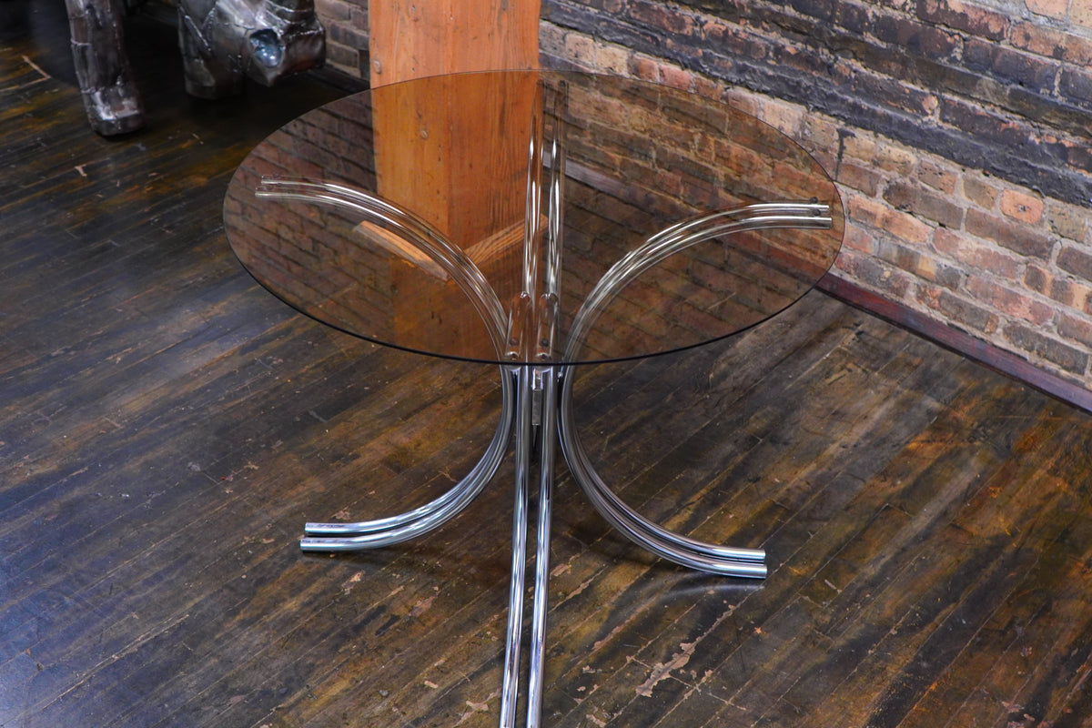 A mid-century modern bistro table with a chrome base and smoke glass top (that is 36" round). Chicago, IL Studio Sonja Milan
