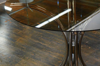A mid-century modern bistro table with a chrome base and smoke glass top (that is 36" round). Chicago, IL Studio Sonja Milan
