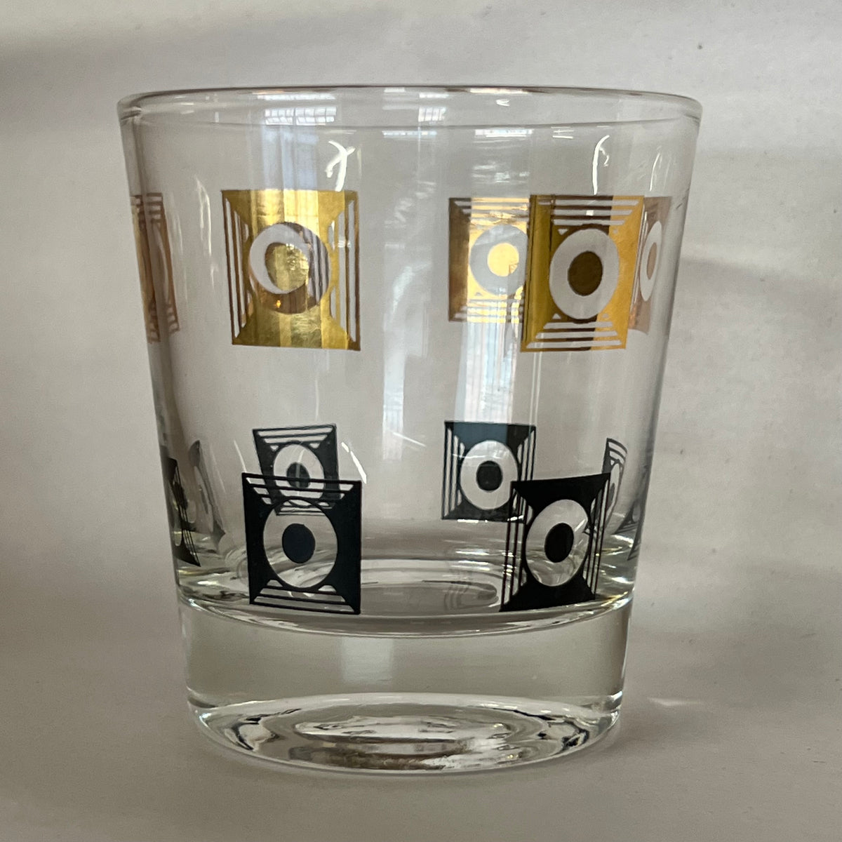 Stunning set of 20 rocks glasses with black and gold motif. Gilding in excellent condition. Almost no wear.No chips. Would be a great and unique addition to a bar. Excellent one-of-a-kind wedding gift. mid-century barware.  Studio Sonja Milan, Chicago.  vintage barware.  Black and gold rocks glasses.