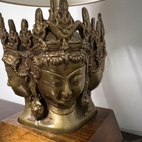 Stunning and unique vintage table lamp. It sits on a wood base. There are 4 crowned asian female faces as part of the base. They appear to be cast in brass or bronze. 