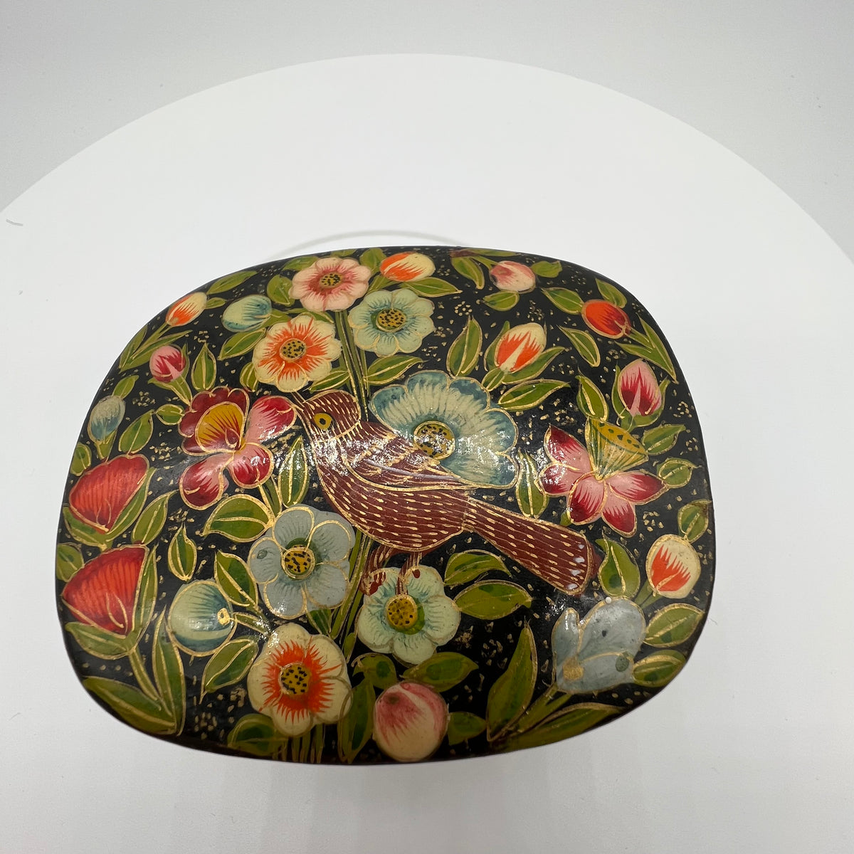 Lovely and finely detailed hand-painted Kashmiri paper cache trinket box. Features flowers, leaves and a bird on a black background.All sides and top of box are painted. 