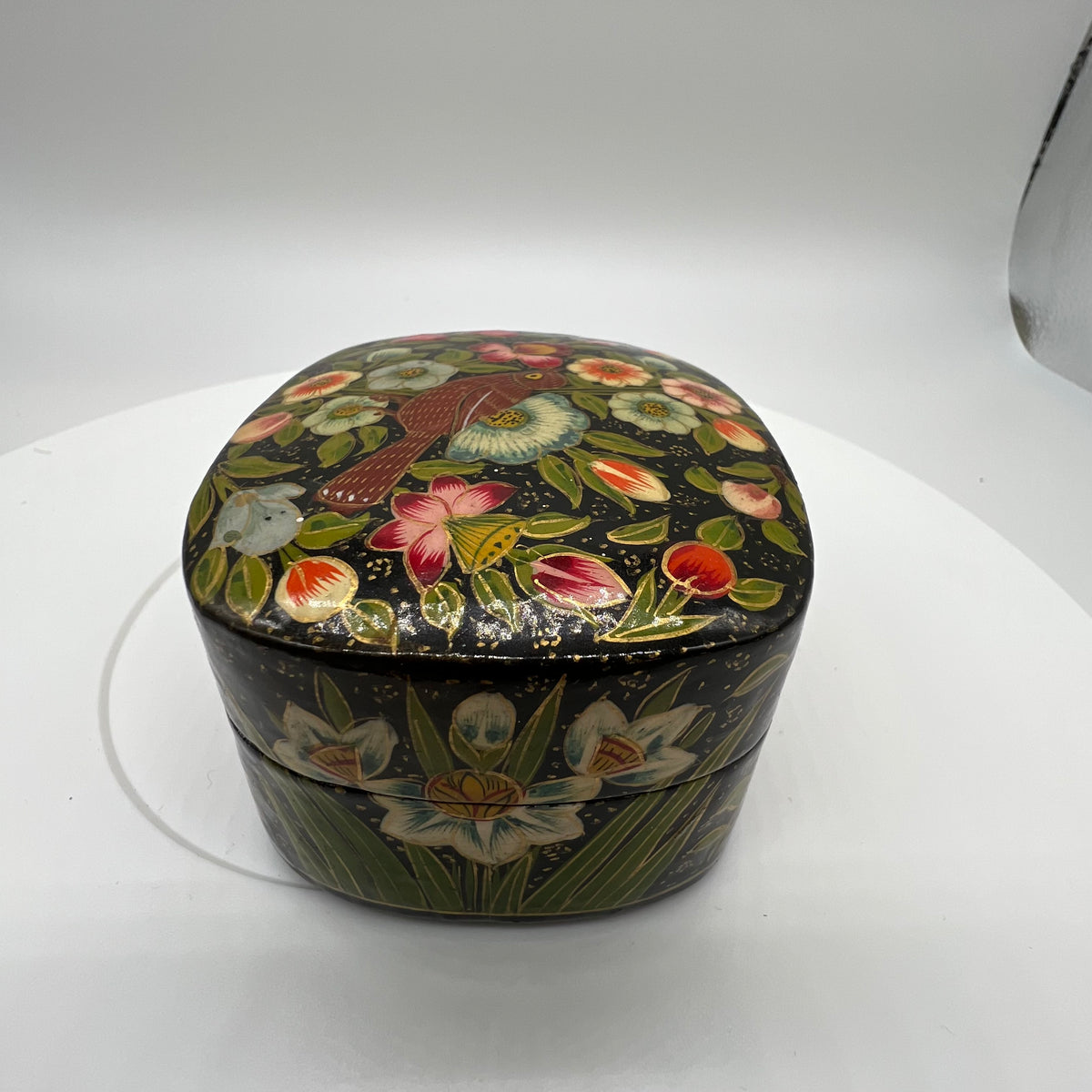 Lovely and finely detailed hand-painted Kashmiri paper cache trinket box. Features flowers, leaves and a bird on a black background.All sides and top of box are painted. 