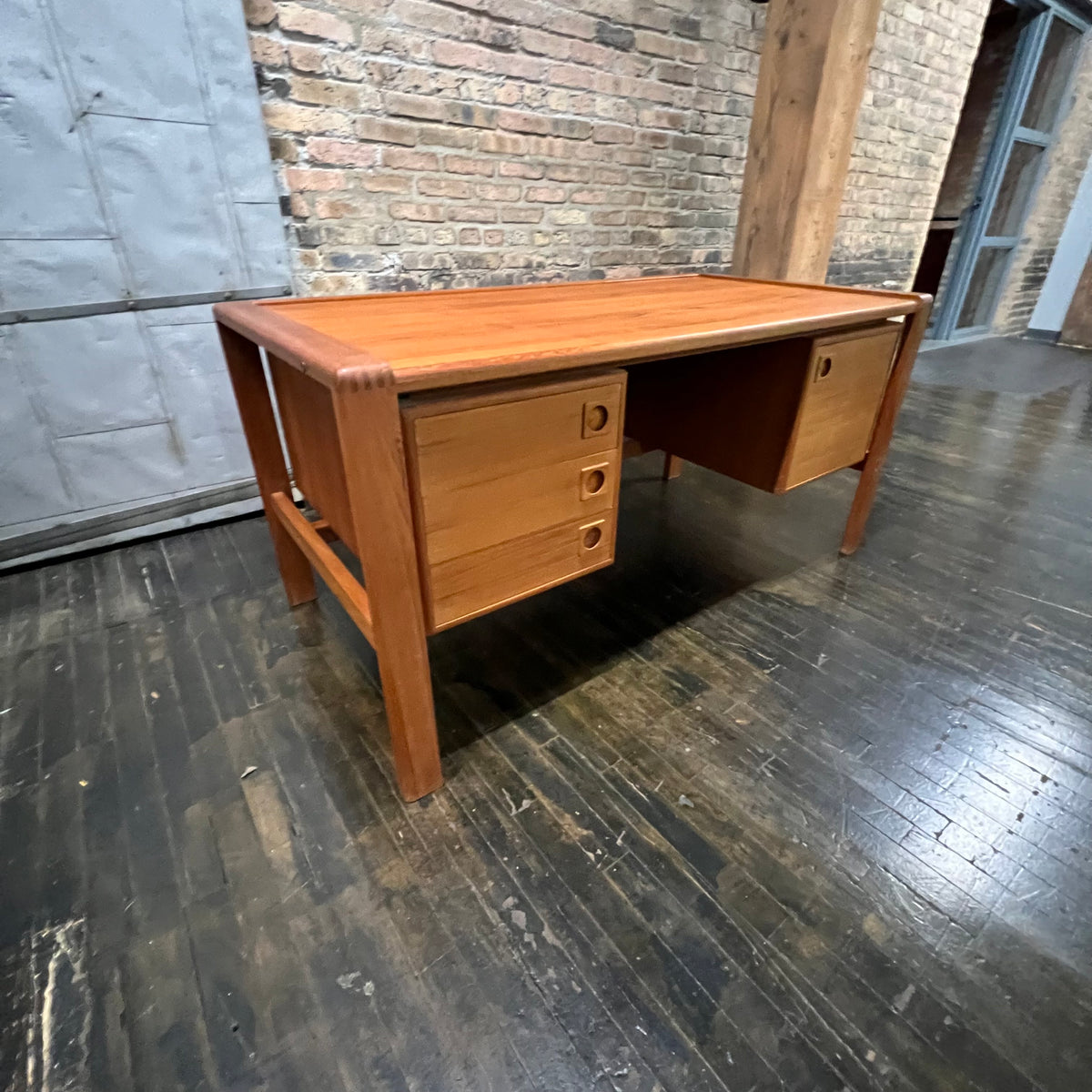 Mid-century executive floating top desk by H.P. Hansen manufactured in Demark circa 1970s. This beautiful desk was made of the highest quality teak.  The back of the desk is completely finished and has one inset opening that can be used for book storage or to display decorative items. STUDIO SONJA MILAN, Chicago, IL