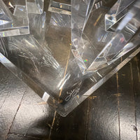 A console table with a glass top and lucite base that almost appears to be stalagmites or ice crystals