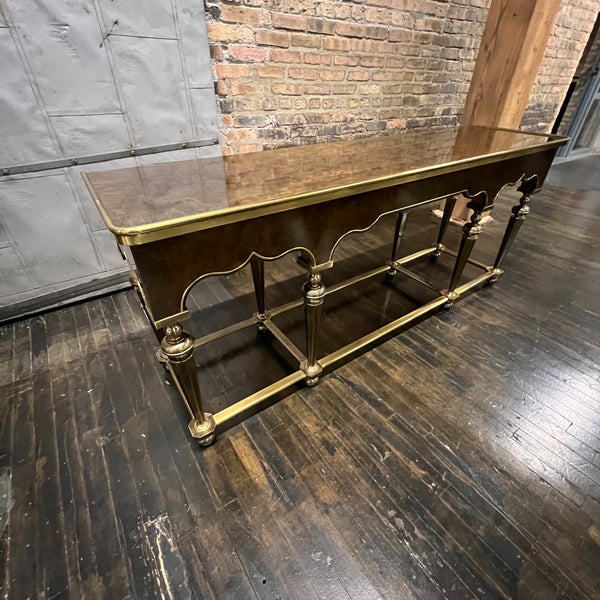 Lovely Hollywood Regency Console Table attributed to Mastercraft.  Burl wood top and apron with brass detail.  It sits on 8 brass legs with brass supports between the legs.  