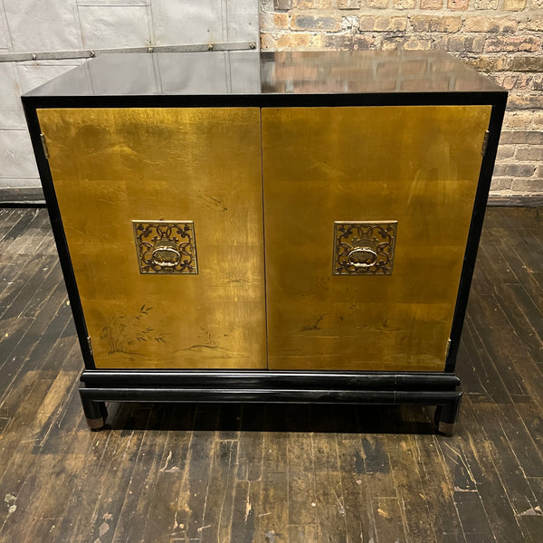 Chinoiserie style black lacquer cabinet with gilded (golden) doors that have images of birds, mountains and grasses painted in the gilding.  