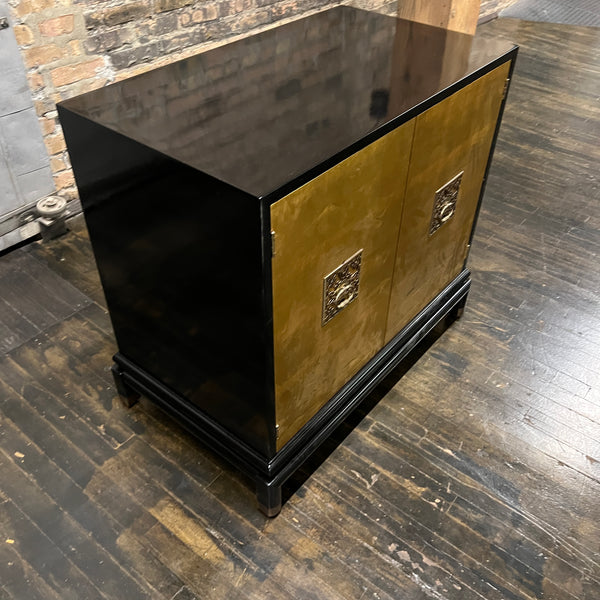 Chinoiserie style black lacquer cabinet with gilded (golden) doors that have images of birds, mountains and grasses painted in the gilding.  