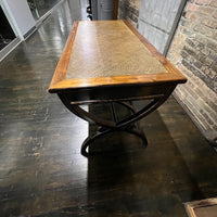 Black lacquer desk that has two "S" shaped legs that cross each other (a sort of hourglass shape). There is a smooth rattan inlay set within the desk's work surface. It has three drawers for storage with simple hardware.