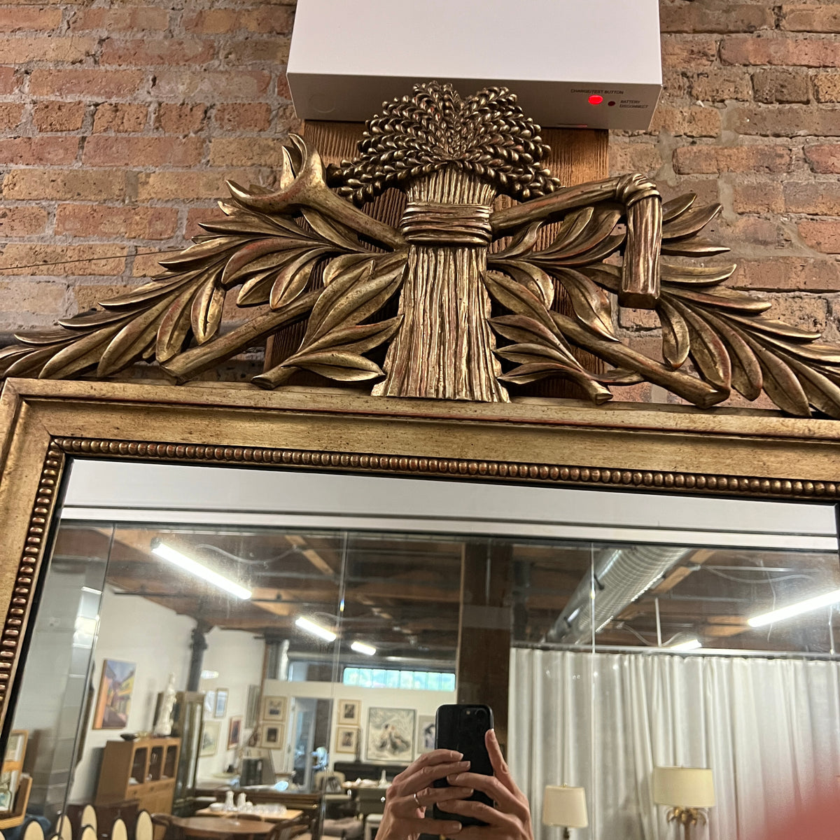 Lovely gilt mirror, one of two available.  At the top of the mirror there is a sheaf of wheat, crescent and laurel leaves at the top and beautiful details at the sides and bottom of the mirror frame.  