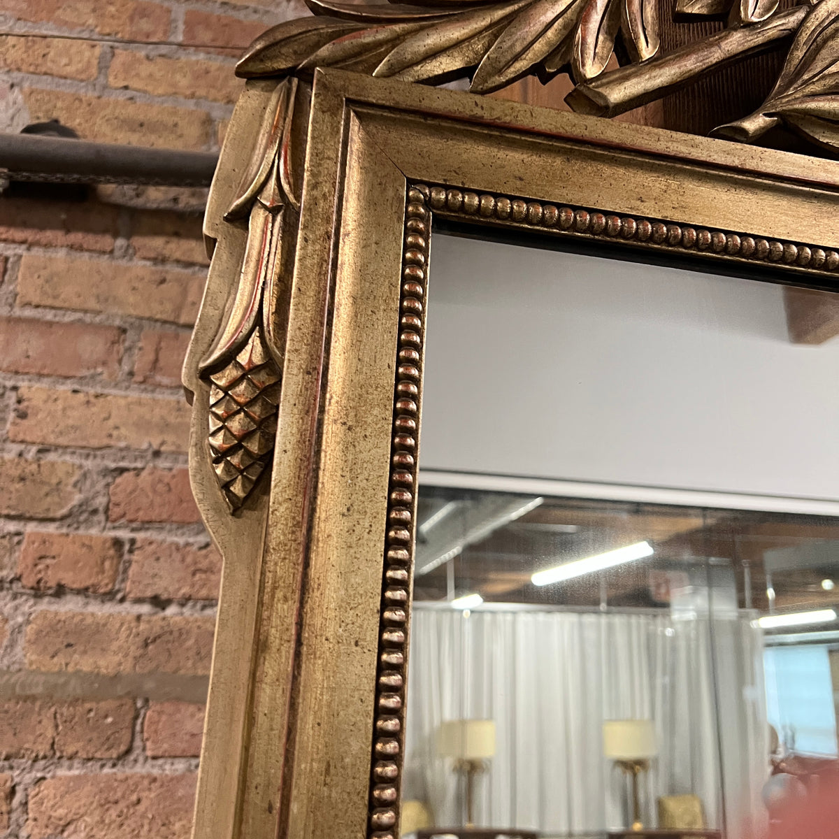 Lovely gilt mirror, one of two available.  At the top of the mirror there is a sheaf of wheat, crescent and laurel leaves at the top and beautiful details at the sides and bottom of the mirror frame.  