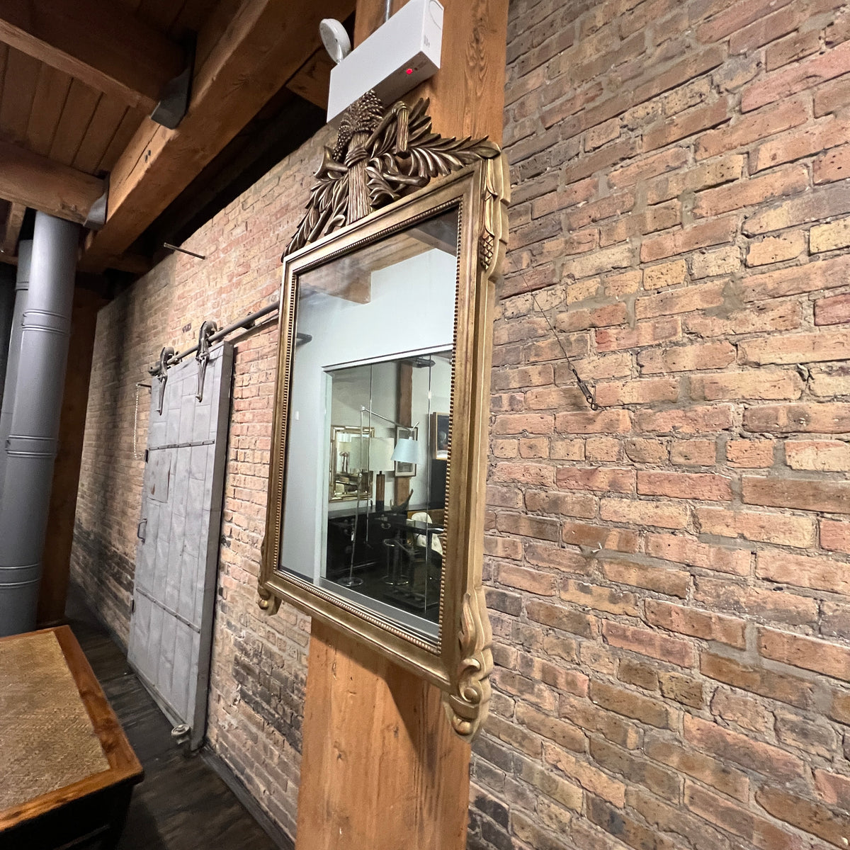 Lovely gilt mirror, one of two available.  At the top of the mirror there is a sheaf of wheat, crescent and laurel leaves at the top and beautiful details at the sides and bottom of the mirror frame.  