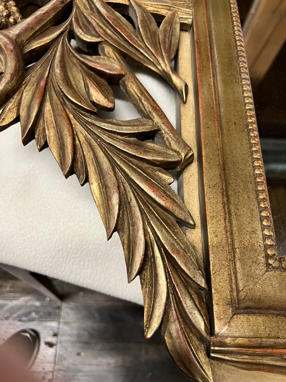 Lovely gilt mirror, one of two available.  At the top of the mirror there is a sheaf of wheat, crescent and laurel leaves at the top and beautiful details at the sides and bottom of the mirror frame.  
