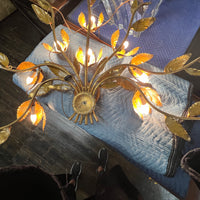 Stunning large gilded wall sconce by Hans Kogl. It has seven arms that have gilded leaves on branches.  Lights are hidden behind certain leaves.  Hollywood Regency Style.  Mid-century corded sconce.