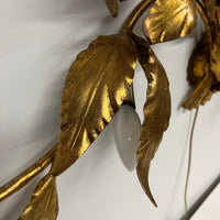 Stunning large gilded wall sconce by Hans Kogl. It has seven arms that have gilded leaves on branches.  Lights are hidden behind certain leaves.  Hollywood Regency Style.  Mid-century corded sconce.