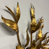 Stunning large gilded wall sconce by Hans Kogl. It has seven arms that have gilded leaves on branches.  Lights are hidden behind certain leaves.  Hollywood Regency Style.  Mid-century corded sconce.
