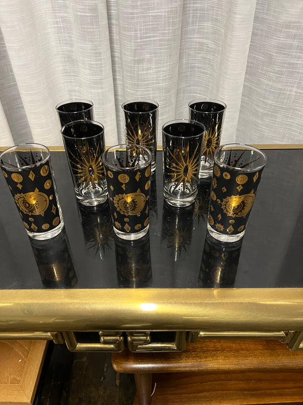 A wonderful set of Fred Press signed mid-century celestial/atomic burst 22-karat gold & black highball glasses. The glasses feature the celestial design; bright bold stars with 22-karat gold and the atomic starburst on one side and a sun/moon eclipse on the other side.  This set appears to never have been used.  Chicago, IL Studio Sonja Milan