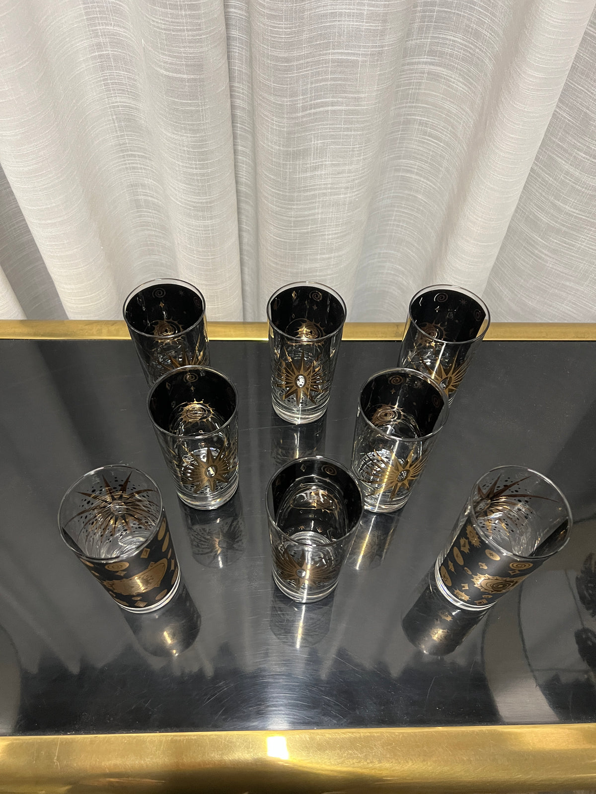 A wonderful set of Fred Press signed mid-century celestial/atomic burst 22-karat gold & black highball glasses. The glasses feature the celestial design; bright bold stars with 22-karat gold and the atomic starburst on one side and a sun/moon eclipse on the other side.  This set appears to never have been used.  Chicago, IL Studio Sonja Milan