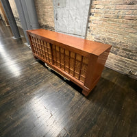 A walnut console cabinet by Berman Rosetti. The piece has 2 doors that slide open to reveal storage inside (one adjustable shelf on either side).  Chicago