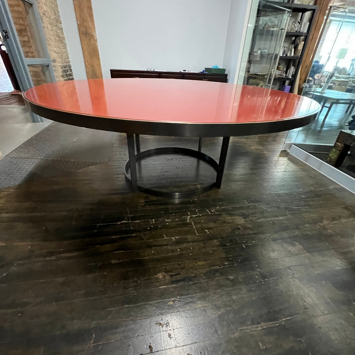 Stunning and impressive solid bronze dining table on an open pedestal base with red lacquer table top.  78" round.  Chicago, IL Studio Sonja Milan