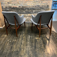 A pair of shell chairs with wood base and gray upholstery. Unmarked. Kofod-Larsen 