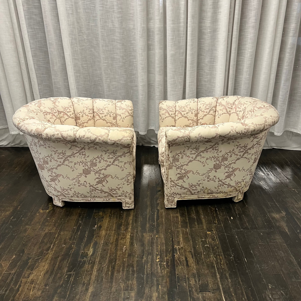 Pair of Art Deco Style Channel Back Lounge Chairs attributed to Baker.  reupholstered some time in the late 70's.  The existing fabric has shades of mauve and lavender on a cream colored background. The fabric is in good shape....but there are some stains at the base of the chair and the arms.  Chicago, IL