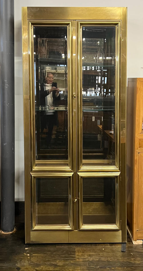Lovely brass and glass vitrine by Mastercraft. The cabinet features 4 doors and several adjustable glass shelves. The inside of the cabinet has antique glass.