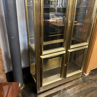Lovely brass and glass vitrine by Mastercraft. The cabinet features 4 doors and several adjustable glass shelves. The inside of the cabinet has antique glass.
