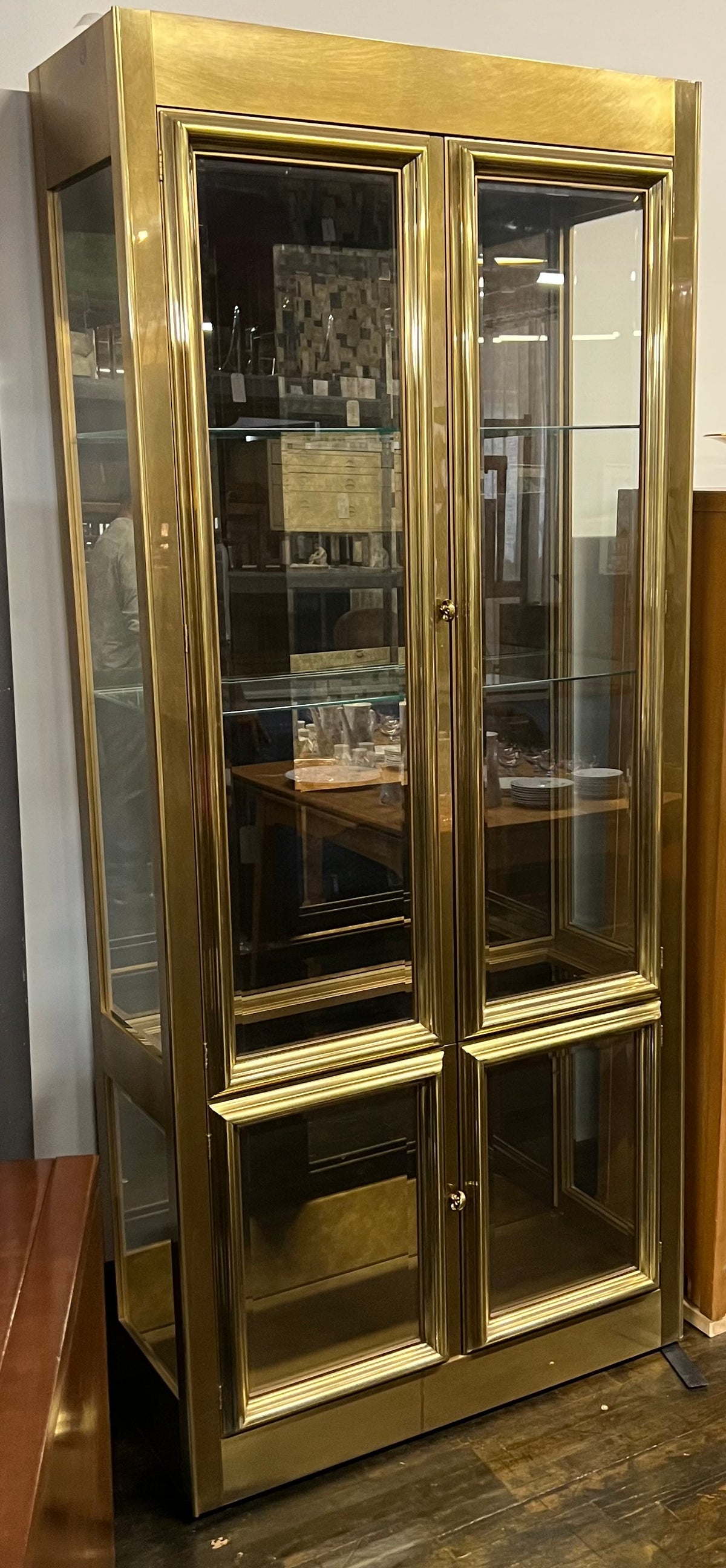 Lovely brass and glass vitrine by Mastercraft. The cabinet features 4 doors and several adjustable glass shelves. The inside of the cabinet has antique glass.