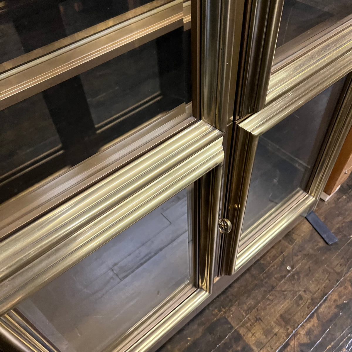 Lovely brass and glass vitrine by Mastercraft. The cabinet features 4 doors and several adjustable glass shelves. The inside of the cabinet has antique glass.