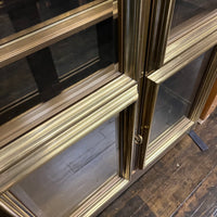 Lovely brass and glass vitrine by Mastercraft. The cabinet features 4 doors and several adjustable glass shelves. The inside of the cabinet has antique glass.