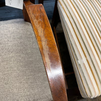 Close-up of a wooden chair arm and a textured surface