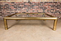 A beautiful, substantial, square brass and glass coffee table by Mastercraft. Thick tubular brass frame with subtle ring detail at the base of each leg.