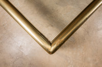 A beautiful, substantial, square brass and glass coffee table by Mastercraft. Thick tubular brass frame with subtle ring detail at the base of each leg.