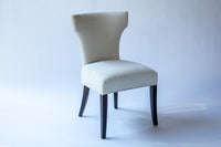 Cream colored upholstered bullhorn style dining chair