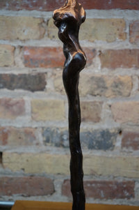 Limited Edition. Signed and numbered bronze sculptures grace the base of this stunning table lamp that is often mistaken for a Giacometti styled female figure. Two versions (similar yet not identical) make the perfect pair of lamps. Rooted melds art (sculpture) and function (lamp). Exclusive to Chicago location.