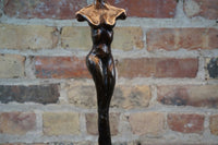 Limited Edition. Signed and numbered bronze sculptures grace the base of this stunning table lamp that is often mistaken for a Giacometti styled female figure. Two versions (similar yet not identical) make the perfect pair of lamps. Rooted melds art (sculpture) and function (lamp). Exclusive to Chicago location.